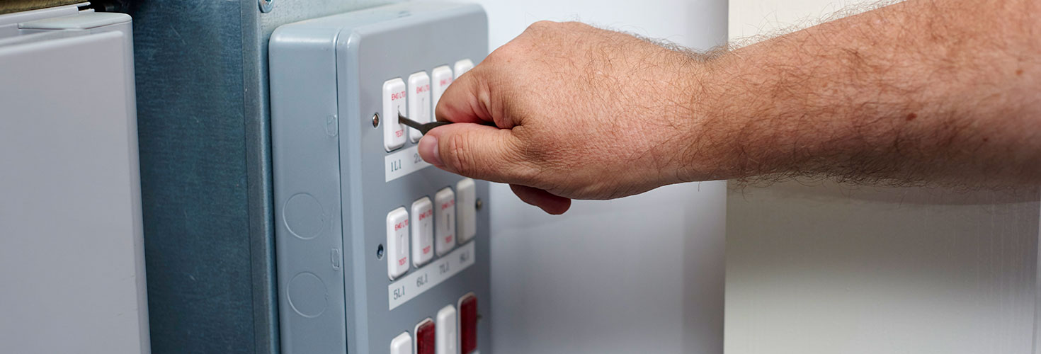 Using specialised electrical testing key to ensure fire alarm and exit lighting is still working